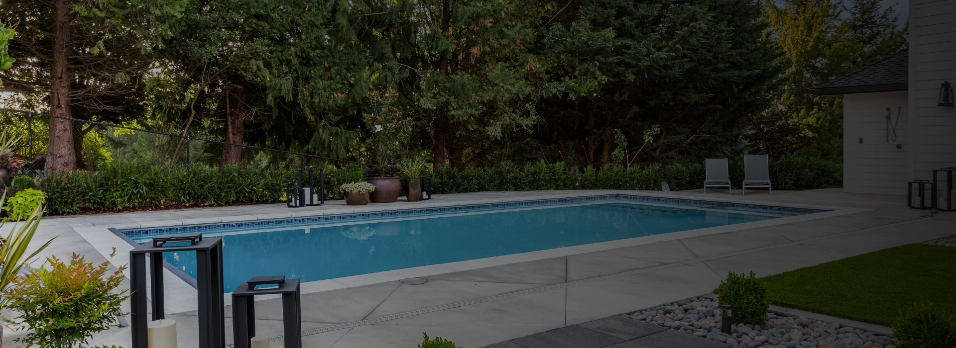 Backyard swimming pool surrounded by trees.